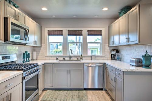 a kitchen with white cabinets and stainless steel appliances at Coastal Getaway by Pebble Beach and Redwoods! in Crescent City