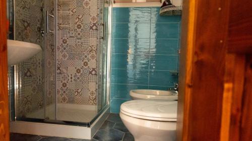 a bathroom with a toilet and a glass shower at La Casa di Elisabetta in Agrustos