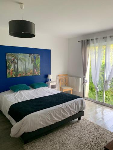 une chambre avec un grand lit avec un mur bleu dans l'établissement LE GITE COTE D OPALE, à Calais