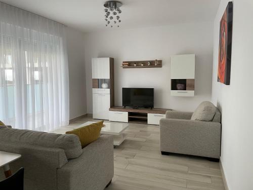 uma sala de estar com dois sofás e uma televisão em Vela Luxury Sea View Apartments - Marina Surf em Mamaia Nord – Năvodari