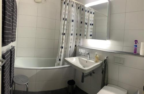 uma casa de banho com um lavatório, um WC e uma banheira em Quellenhof C01 em Davos