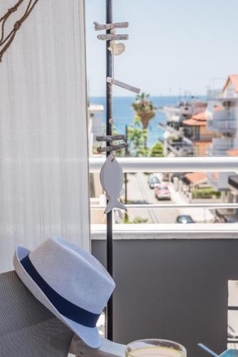 a hat sitting on a table in front of a window at Aqua Mare Hotel in Nea Kalikratia