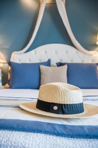 a straw hat sitting on top of a bed at Aqua Mare Hotel in Nea Kalikratia