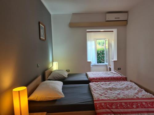 a bedroom with two beds and a window at Apartments Šeherzada in Pula