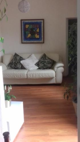 a living room with a white couch with pillows on it at Casa Cris in Brentonico