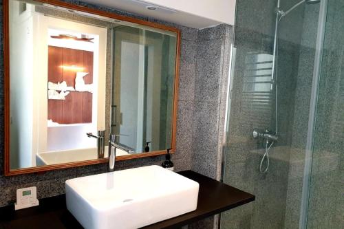 a bathroom with a sink and a glass shower at Bright & Modern Studio With Great Sun Exposure in Paris