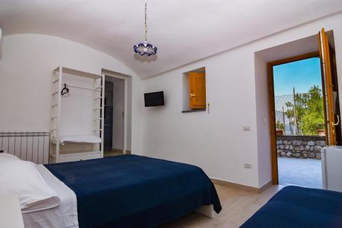 a white room with a bed and a window at Villa Mariagiovanna - Casa Giovanna in Vico Equense
