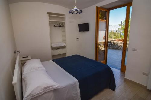 a bedroom with a bed and a door to a balcony at Villa Mariagiovanna - Casa Giovanna in Vico Equense