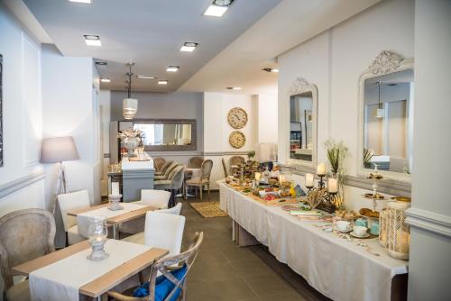 a dining room with tables and chairs and mirrors at Aqua Mare Hotel in Nea Kalikratia