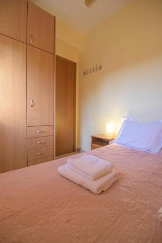 a bedroom with a bed with two towels on it at Kostas & Eleni Apartments in Sotirítsa
