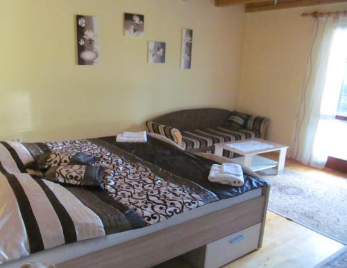 a bedroom with a bed and a couch at A+S Penzion Podzamok in Spišské Podhradie