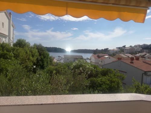 a view of a lake from a window at Riviera Rooms and Apartments in Rab