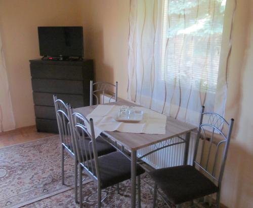 a dining room table with chairs and a television at A+S Penzion Podzamok in Spišské Podhradie