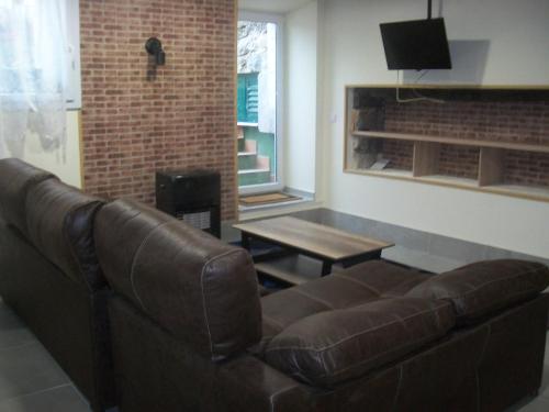 Una sala de estar con un sofá de cuero y una mesa. en AGARRE URDAIBAI, en Mundaka