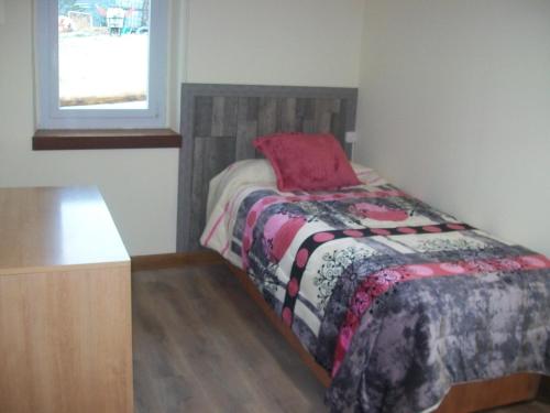 Un dormitorio pequeño con una cama y una ventana. en AGARRE URDAIBAI, en Mundaka