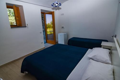 a bedroom with a bed and a window and a door at Villa Mariagiovanna - Casa Giovanna in Vico Equense