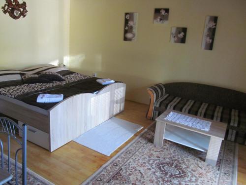 a bedroom with a bed and a couch and a table at A+S Penzion Podzamok in Spišské Podhradie