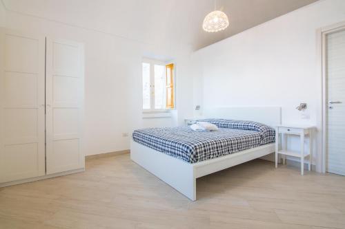 a white bedroom with a bed and a desk at Villa Mariagiovanna - Casa Giovanna in Vico Equense