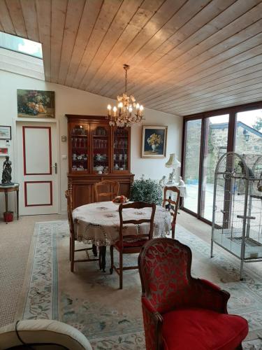 une salle à manger avec une table, des chaises et un lustre dans l'établissement TY KOANT, à Daoulas