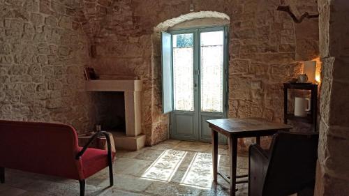 a room with a door and a table and a chair at Masseria LoJazzo in Ceglie Messapica
