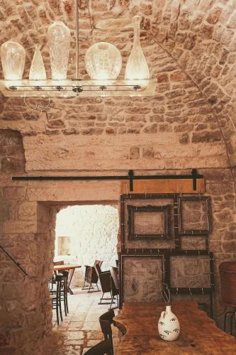 a room with a stone wall with a table and chairs at Masseria LoJazzo in Ceglie Messapica