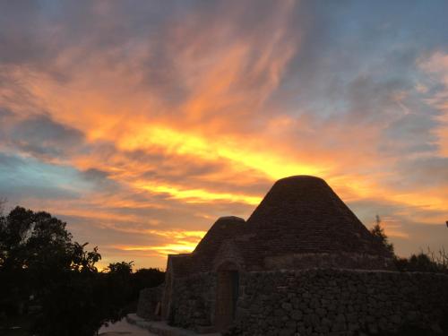 a sunset over the top of a building at Masseria LoJazzo in Ceglie Messapica