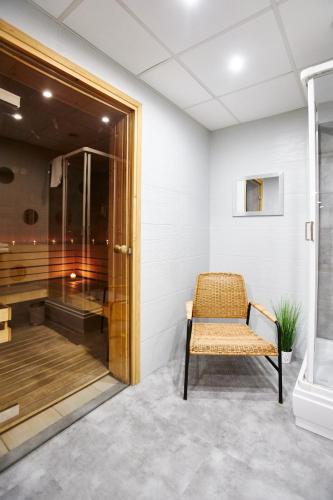 a bathroom with a bench and a shower at Arche Hotel Puławska Residence Warszawa in Warsaw