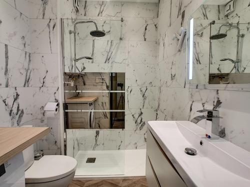 ロワイヤンにあるHermès Plageのトイレと洗面台を備えた白いバスルーム