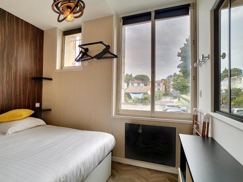 ロワイヤンにあるHermès Plageのベッドとテレビと窓のある寝室