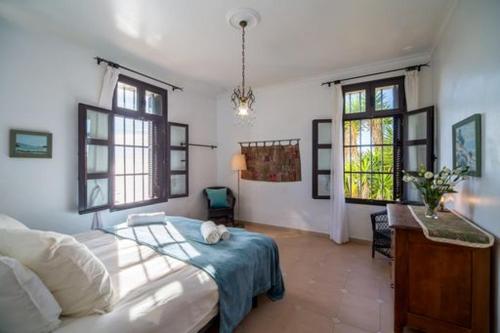 1 dormitorio con 1 cama, escritorio y 2 ventanas en Floating House Tarifa, en Tarifa