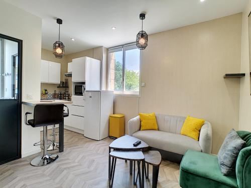 un salon avec un canapé et une cuisine dans l'établissement Hermès Plage, à Royan