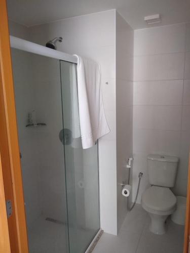 a bathroom with a toilet and a glass shower stall at Acomodação Tranquila (Centro de Campos) in Campos dos Goytacazes