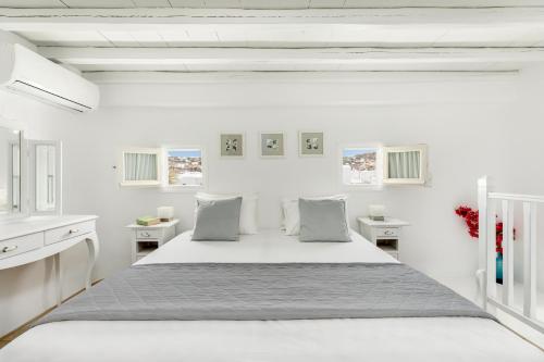 um quarto branco com uma cama grande e paredes brancas em Corfos Hotel em Ornos