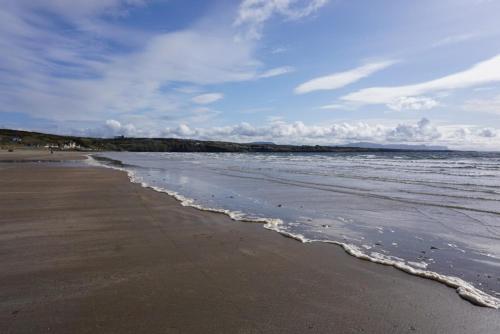 a beach with waves coming in from the ocean at Tirchonaill Townhouse in Donegal