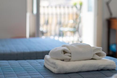 a stack of towels sitting on top of a bed at Bed and Breakfast Terra del Sole Ibla in Ragusa