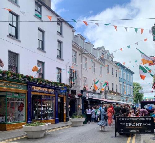 a busy street in a city with shops and people at 7 Boutique Hotel in Galway