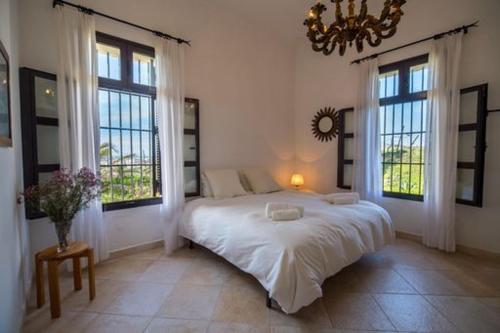 1 dormitorio con 1 cama blanca grande y ventanas en Floating House Tarifa, en Tarifa