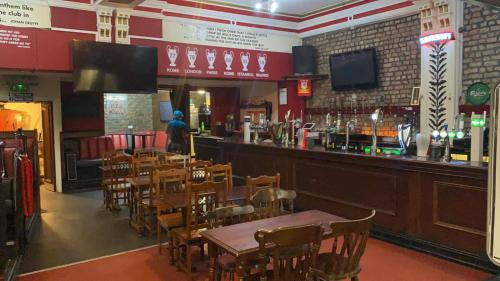 un restaurant avec un bar doté de tables et de chaises en bois dans l'établissement Brownlows Inn Guest House formerly The King Harry Accommodation, à Liverpool