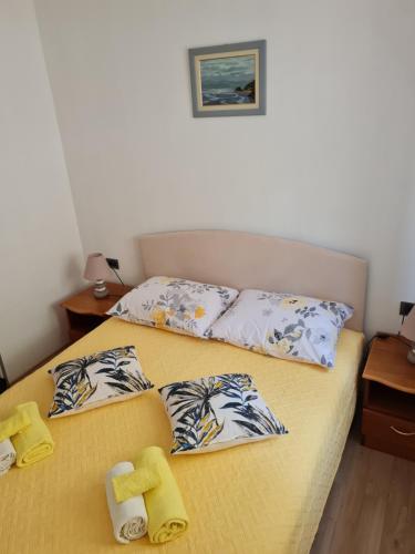 a bedroom with a bed with pillows on it at Apartments Hana in Goveđari