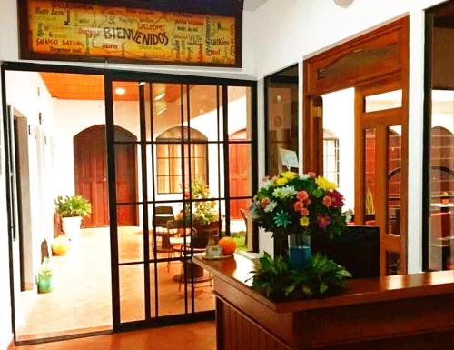 a restaurant with glass doors and flowers on a counter at Hostal Las Puertas in Santa Ana