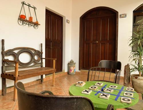 a room with a table and chairs and a bench at Hostal Las Puertas in Santa Ana