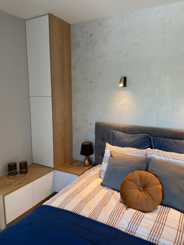 a bedroom with a bed with a pillow on it at Apartament Marble Wave Rowy in Rowy
