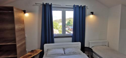 a bedroom with a bed and a window with blue curtains at Villa Natali in Ohrid