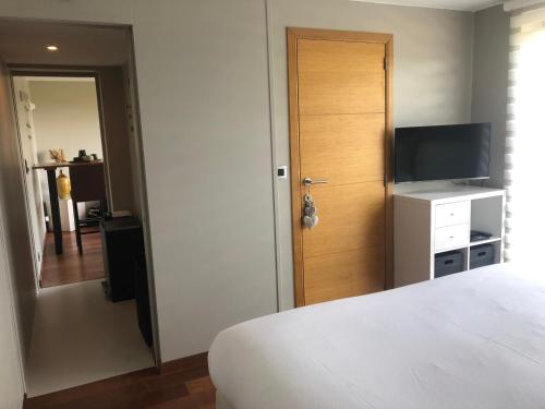 Schlafzimmer mit einem Bett und einer Tür mit einem TV in der Unterkunft Chez Emma in Stavelot