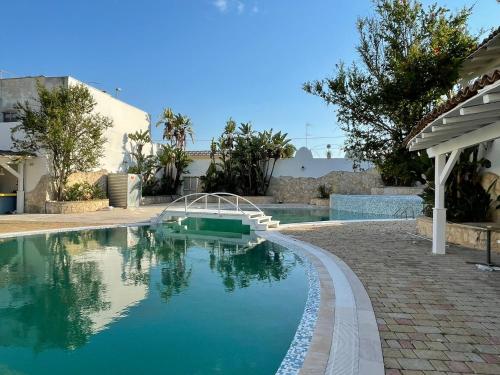 uma piscina ao lado de uma casa com piscina em Gatto Bianco Casalabate em Casalabate