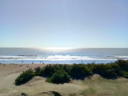 a group of people on a beach near the ocean at Mar del Este in San Bernardo
