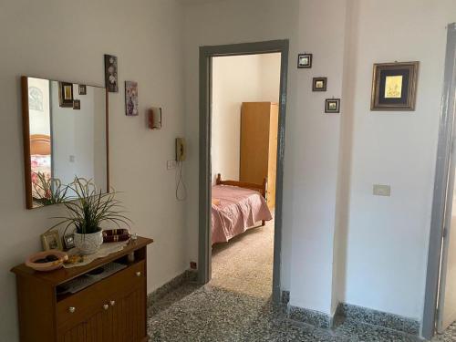 Habitación con dormitorio con cama y espejo. en Casa Vacanza Santa Teresa di Riva, en Santa Teresa di Riva