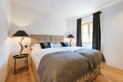 a bedroom with a large bed and a window at Chalet Marmotta NEVE - Luxus Chalet in Sankt Anton am Arlberg