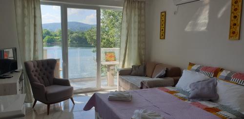 a living room with a bed and a large window at Apartman tipa studio BMB in Veliko Gradište