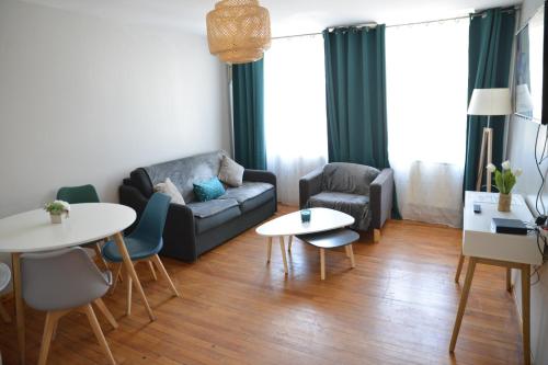 un salon avec un canapé, une table et des chaises dans l'établissement sweet In apartment, à Anzin